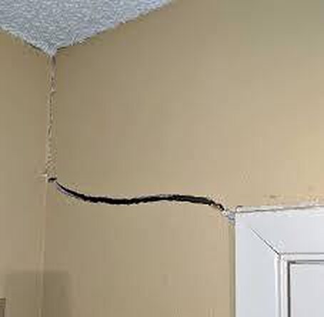 Crack running along the wall and ceiling corner above a doorway
