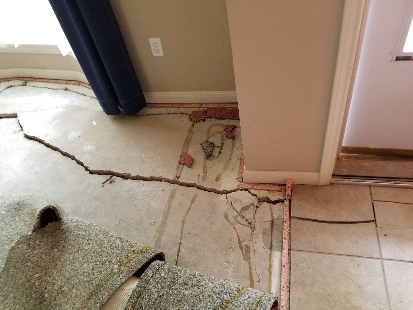 Settled interior slab floor with a crack running toward the doorway