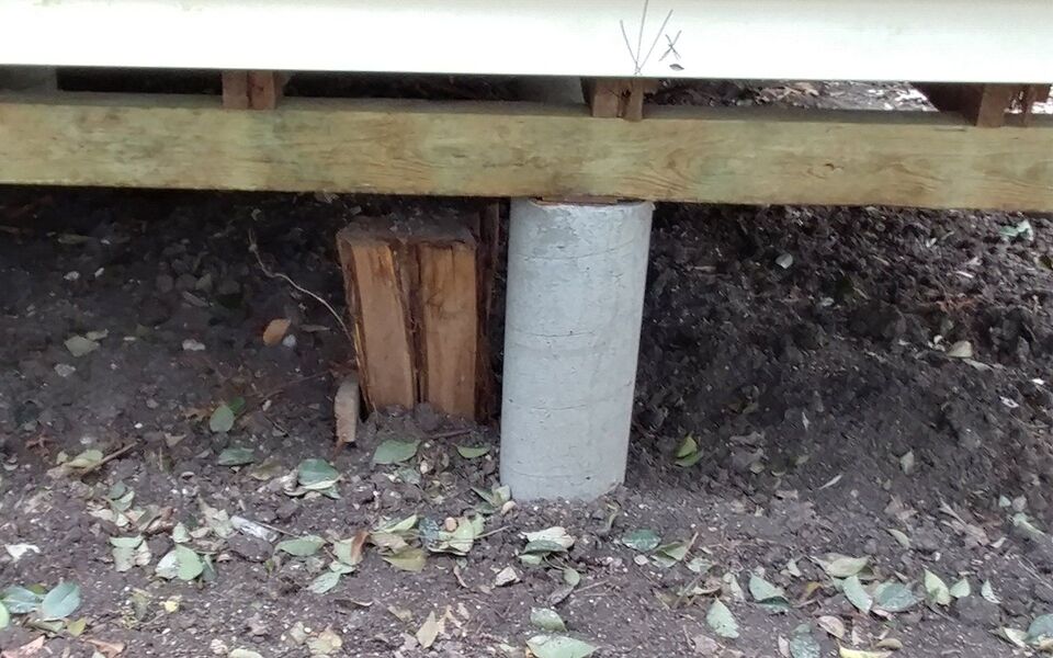 Shimmed pier stack supporting a beam under an older home