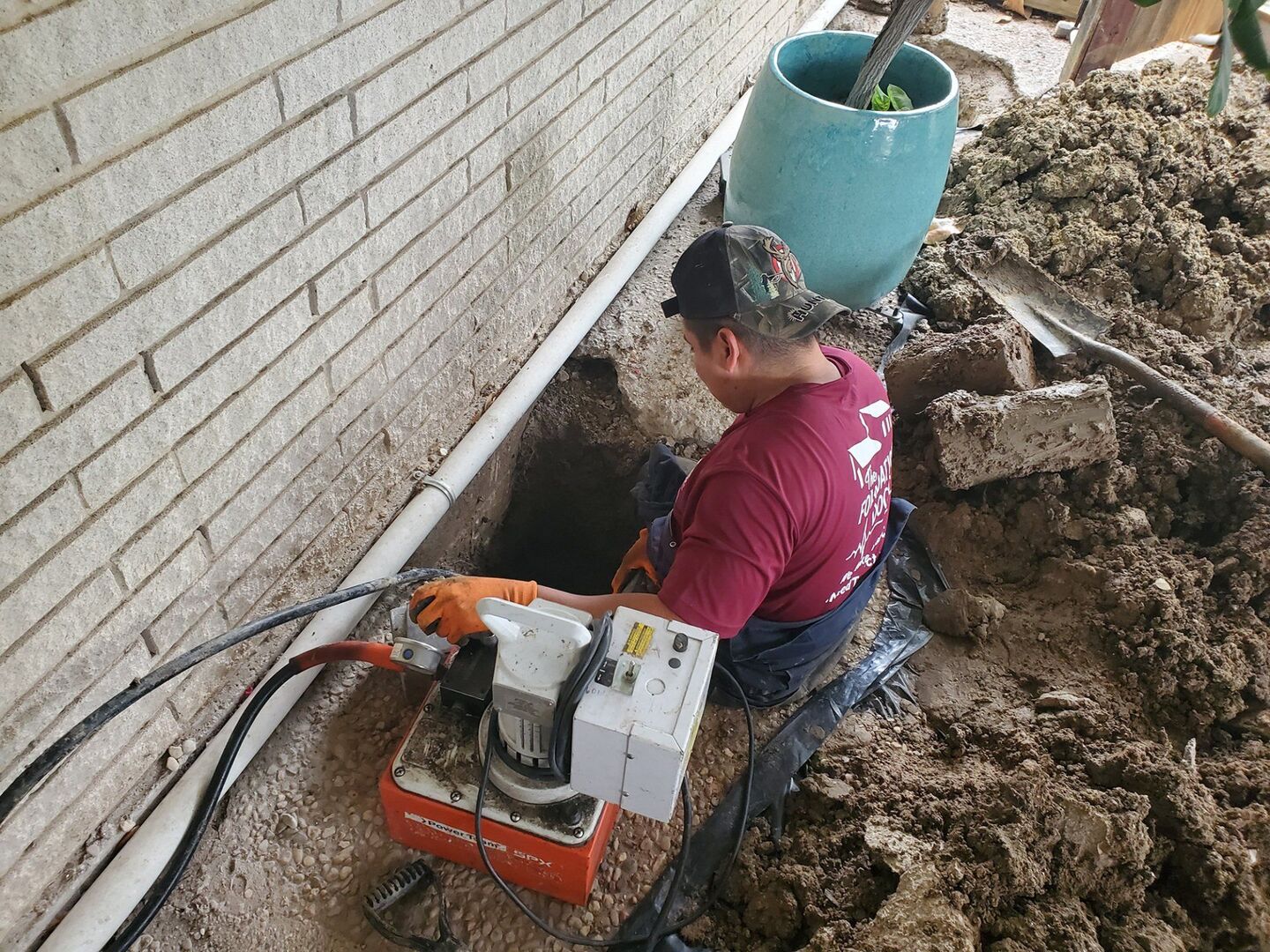 Foundation Doctor crew member pressing a concrete pier with a hydraulic pump