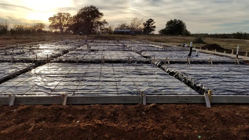 Building pad prepared with rebar grid at sunset on Central Texas acreage