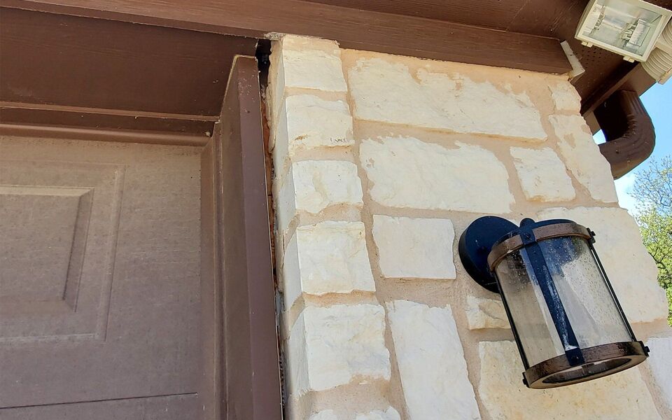 Stone column separating from trim at a garage corner